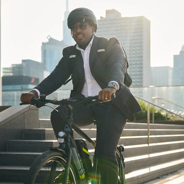 Business man commuting to work with Bern Hudson helmet on while riding an e-bike.