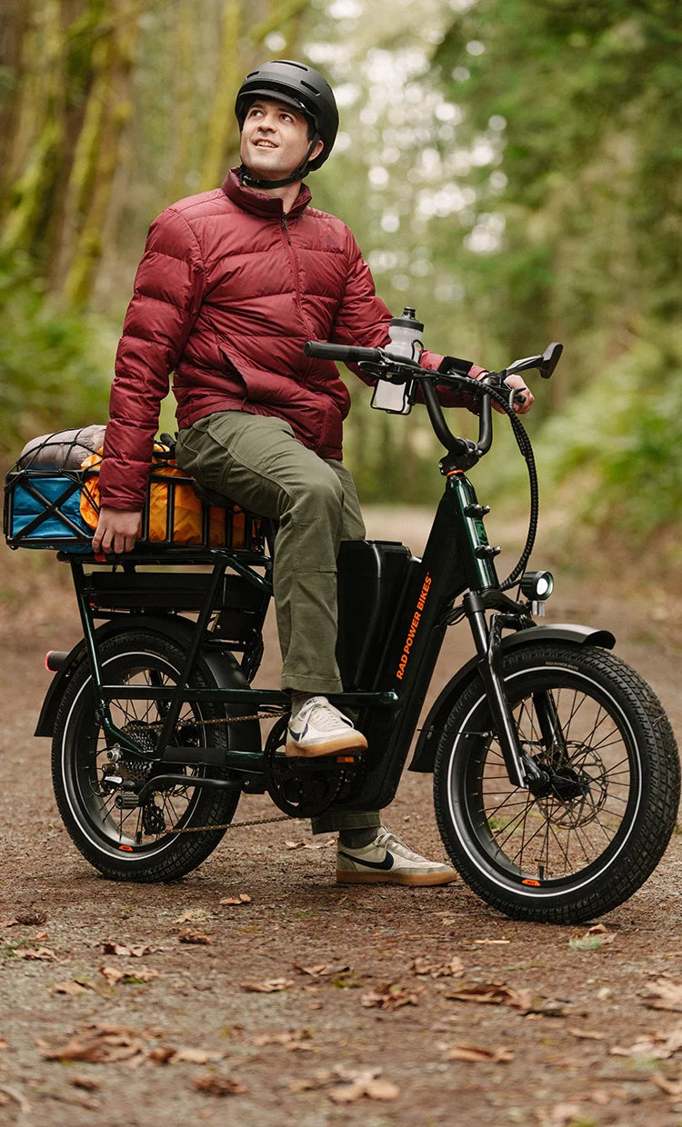 Rider wearing Bern Hudson NTA-8776 certified e-bike helmet while commuting on electric bike in woods.