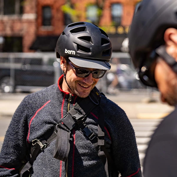 Bike rider wearing Bern Allston DVRT helmet, visor flipped down to help shade eyes from the sun.