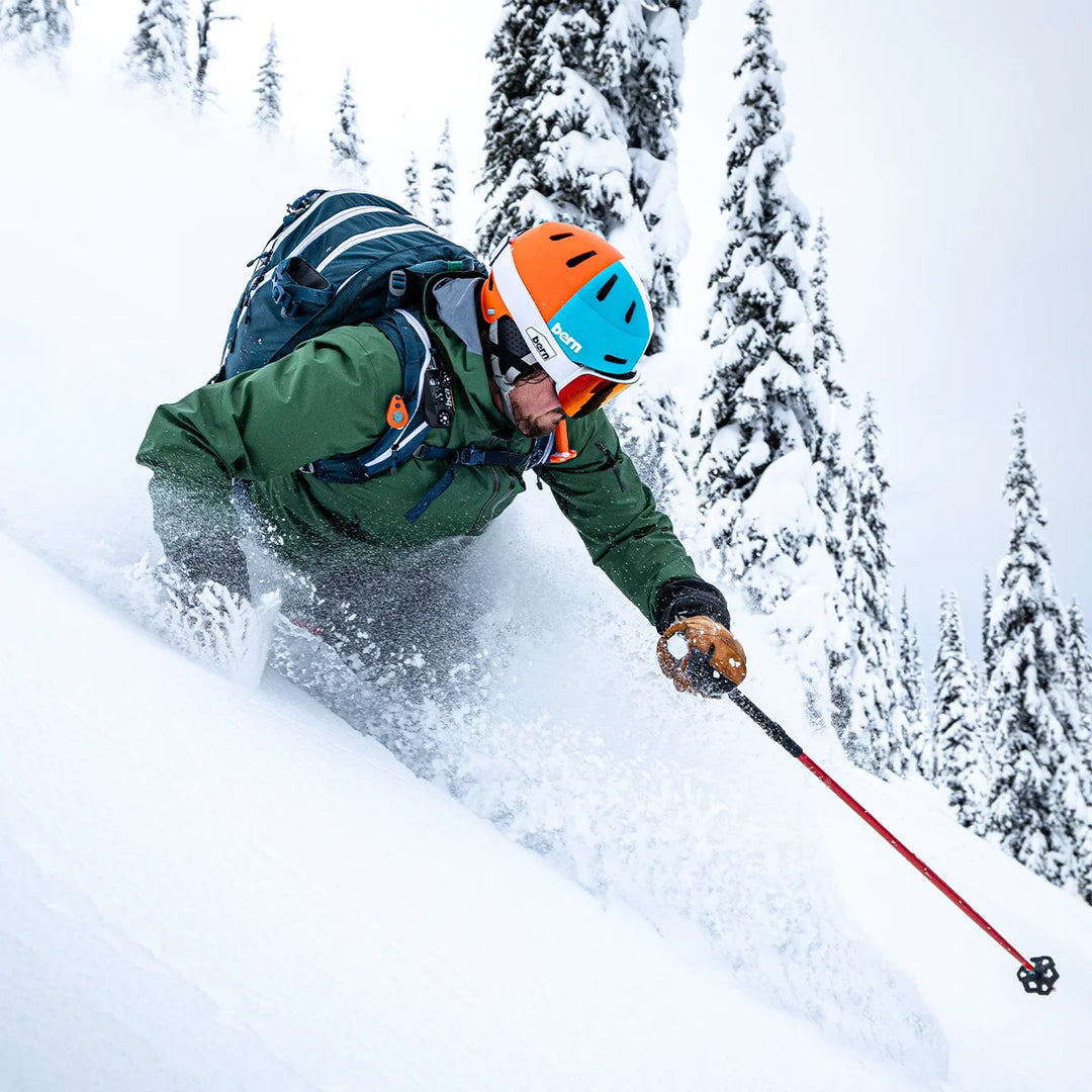 person skiing in heavy conditions wearing macon 2.0 winter helmet, color tritone blue orange white